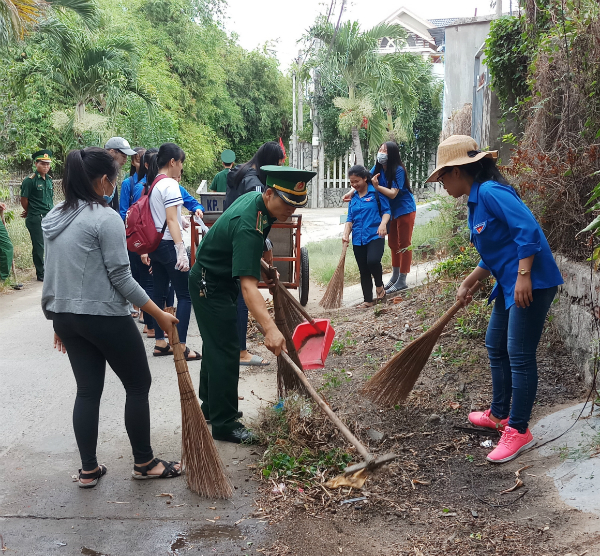 Các đoàn viên, thanh niên tham gia làm vệ sinh, tẩy xóa quảng cáo và cắm cờ Tổ quốc.